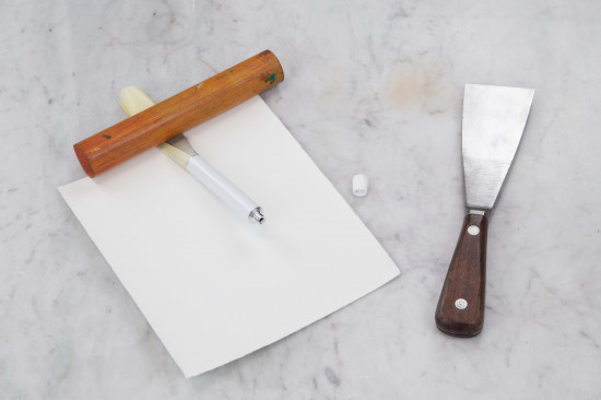 Use a short round wooden stick, about the diameter of a broomstick and about 15 centimeters long and roll it on the paper from the back to the front, so the oil paint is pressed into the tube.