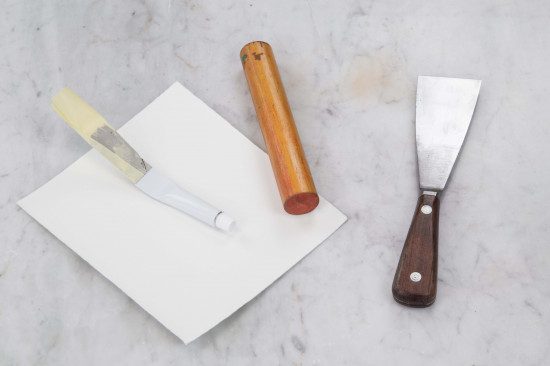 Close the cap and flatten the end of the tube with the wooden stick.